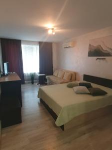 a hotel room with a bed and a couch at студия ЛИЛИЯ in Tsarevo