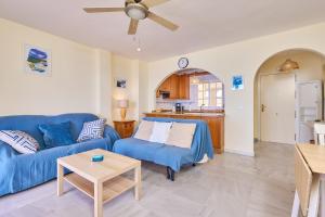 a living room with a blue couch and a table at Blue View in Torrox Costa