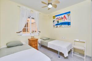 a bedroom with two beds and a ceiling fan at Blue View in Torrox Costa