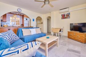 a living room with a blue couch and a tv at Blue View in Torrox Costa
