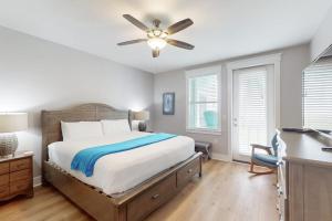 a bedroom with a bed and a ceiling fan at Sand Swept in Galveston