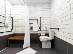 a bathroom with a toilet and a bath tub at ibis Ponta Grossa in Ponta Grossa +51 photos