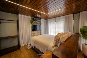 a bedroom with a large bed and a window at Hotel Fazenda Gabro - Vitra in Apiaí