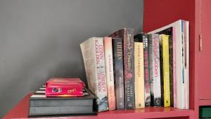 a shelf with a bunch of books on it at Knysna Holiday Cottage in Knysna