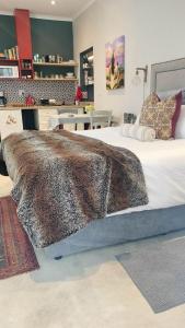 a bedroom with a large bed with a blanket at Knysna Holiday Cottage in Knysna