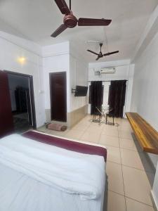a bedroom with a bed and a ceiling fan at Sea Breeze Residency in Kozhikode