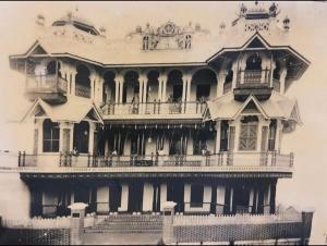 an old photo of a large house with a balcony at Umbrella Comfy Stays-Subbu in Madurai