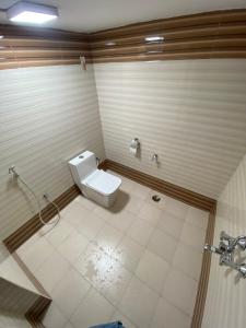 a bathroom with a white toilet in a stall at Umbrella Comfy Stays-Subbu in Madurai