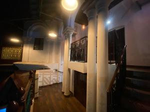 a hallway with columns and a staircase in a building at Umbrella Comfy Stays-Subbu in Madurai