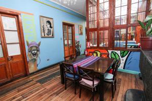 a dining room with a table and a dog painted on the wall at La Chimba Hostel in Santiago