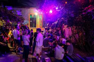 a crowd of people standing in a yard at night at La Chimba Hostel in Santiago +50 photos