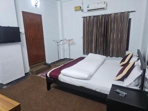 a bedroom with a bed and a television in a room at Sea Breeze Residency in Kozhikode