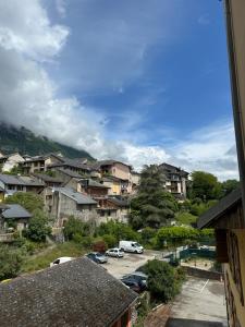 a city with cars parked in a parking lot at Les Suites du Quai in Montmélian