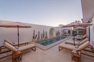 a swimming pool with benches and umbrellas and a pool at Abasolo Clubhouse in La Paz