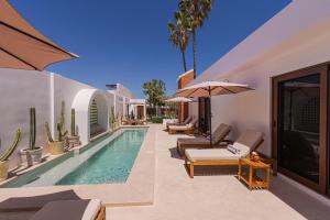 a villa with a swimming pool with chaise lounges at Abasolo Clubhouse in La Paz