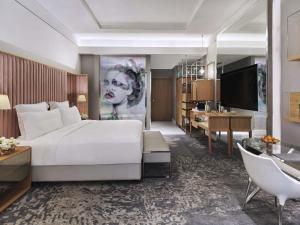 a bedroom with a large white bed and a desk at SLS Dubai Hotel & Residences in Dubai