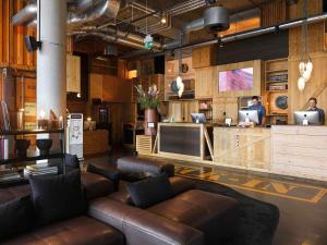 a lobby with leather furniture and a reception desk at 25hours Hotel Hamburg HafenCity in Hamburg