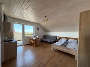 a bedroom with a bed and a couch and a table at Flota in Ostrowo