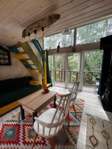 a living room with a table and chairs and a staircase at Апартаменти Smereka in Yablunytsya