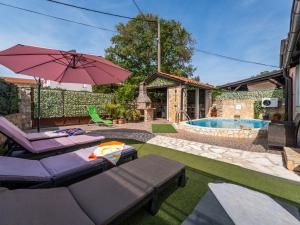 a patio with chairs and an umbrella and a pool at Holiday Home Ana by Interhome in Šilo
