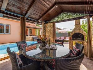 an outdoor patio with a table and chairs and a fireplace at Holiday Home Ana by Interhome in Šilo