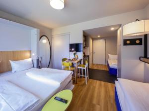 a hotel room with two beds and a table at Adagio Access Stuttgart Airport Messe in Leinfelden-Echterdingen