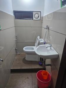 a small bathroom with a toilet and a sink at Sea Breeze Residency in Kozhikode +3 photos