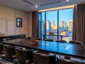 a conference room with a table and chairs and a large window at Sofitel Adelaide in Adelaide +160 photos