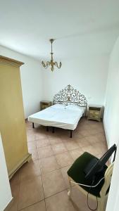 a bedroom with a bed and a chair and a chandelier at Casa Tassistro in Pareto
