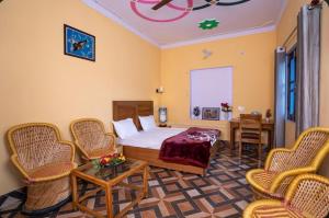 a bedroom with a bed and a table and chairs at Devki Homestay in Kanatal