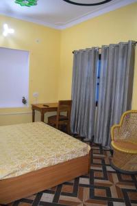 a bedroom with a bed and a window and a table at Devki Homestay in Kanatal