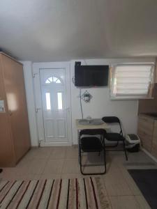 a room with a door and a table and chairs at Smeštaj Vrhovac in Vrdnik