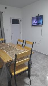 a table and bench with a tv on the wall at Brisa de Pueblo in Caseros