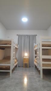 a room with three bunk beds and a table at Brisa de Pueblo in Caseros