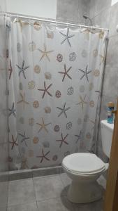 a bathroom with a shower curtain with a toilet at Brisa de Pueblo in Caseros +8 photos