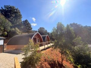 a small red building with a black roof at Recanto sol nascentre cabanas in Monte Verde