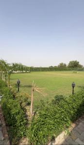 a field with several lights and a field with a field at Aradiya Farm House in Noida