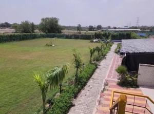 a view of the garden from the balcony of a house at Aradiya Farm House in Noida