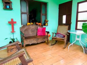 a room with a cross and a table and chairs at Casa Tuta in Ciudad Vieja