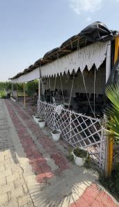 a building with a roof with a row of bowls at Aradiya Farm House in Noida