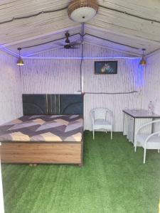 a bedroom with a bed and two chairs and a table at Aradiya Farm House in Noida