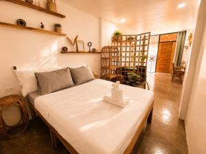 a bedroom with a large white bed in a room at Hiraya Apartments in San Vicente