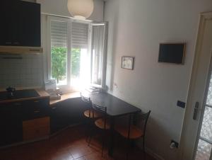 a kitchen with a table and chairs and a window at Modena Sound Suite in Modena