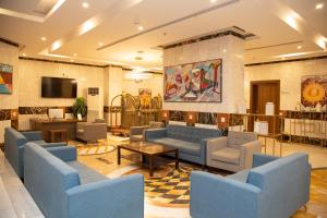 a waiting room with blue couches and a tv at Artal Taiba Hotel in Medina