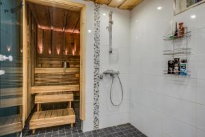 a shower stall with a bench in a bathroom at Holiday Home Kerssintie in Tahkovuori