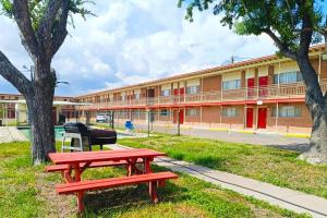 a red picnic table in front of a building at Pen Ann by Capital O Pharr-McAllen TX in Pharr