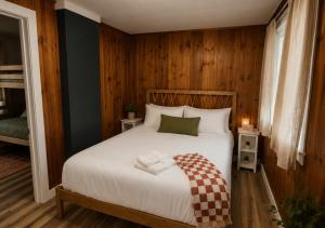 a bedroom with a large bed with wooden walls at Lakeside Heritage Resort in Carp Lake