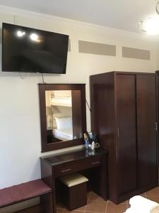 a bathroom with a dresser and a mirror at Elena Rista Studios in Parga