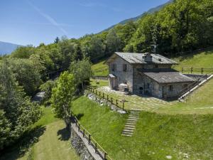 an old stone house on a hill with a fence at Chalet Chalet Anna by Interhome in Grosotto