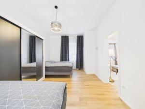 a white bedroom with two beds and a mirror at Ebenerdige Ferienwohnung in Maissau